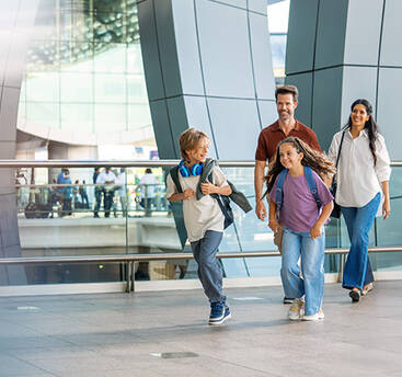 A family of 4 excitedly entering Dubai Airport
