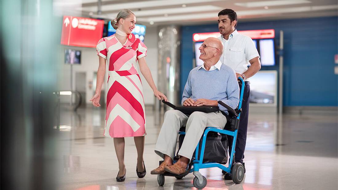 a marhaba representative accompanying a man on a wheelchair